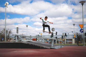 Skater jumping over funbox in skatepark