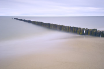 Separation line made of deep logs in the Baltic sea to form a quiet beach