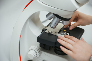 Close-up of laboratory technician using microscope in lab