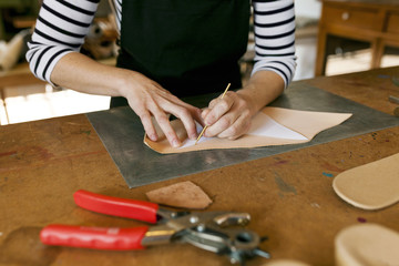 Close-up of shoemaker working on template in her workshop