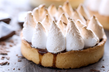 Macro delicious mini tarts (tartlets) with meringue and lemon cream on a background