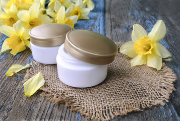 Jar with cosmetic cream on a wooden surface.