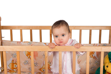 Sad Infant child baby girl toddler in wooden bed on white background