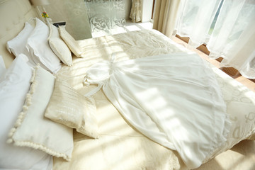 Fototapeta na wymiar wedding dress on beautiful white bed
