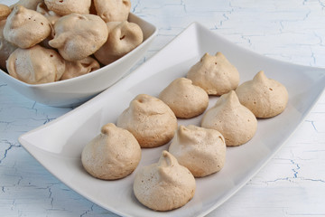 Meringues on crockery plate and light background