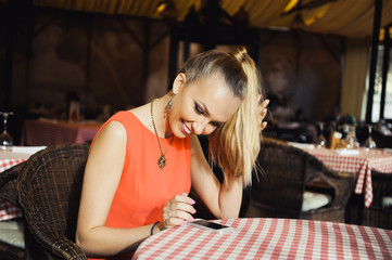 close-up portrait of a beautiful young elegant sexy blonde woman in the cafe with a glass of champagne,White wine smiling and drink posing, with a ring on her finger, she is engaged
