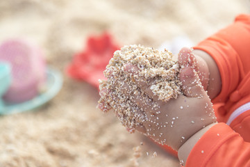 a baby hold sand on the beach
