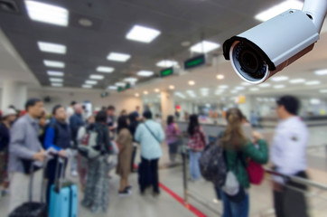 cctv security camera on blurred image of tourist queue at immigration control at airport, security technology concept. - obrazy, fototapety, plakaty