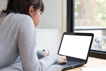 Fototapeta premium asian girl female teenager studying at school. Student lying and typing on laptop - education and learning concept