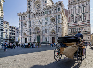 Naklejka na ściany i meble A traditional horse carriage passes near the Duomo in Florence, Italy, on a sunny day
