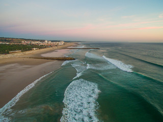 Aerial videoin motion during sunset in the Atlantic Ocean in Costa da Caparica, Lisbon, Portugal.
