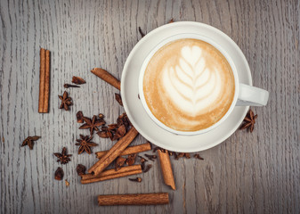 Cappuccino coffee, coffee beans and anise on wood table