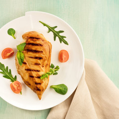 Grilled chicken fillet with cherry tomatoes and salad leaves