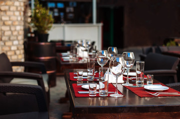 Beautifully decorated table. Preparation for dinner. Summer terrace. Cafe in the street.