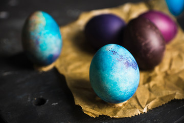 Rustic colored easter eggs on the dark stone background. Shallow depth of field.
