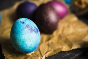 Rustic colored easter eggs on the dark stone background. Shallow depth of field.