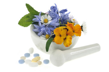 Fleurs dans un mortier avec un pilon et des médicaments