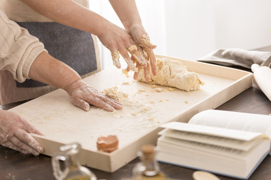 Women preparing a dough on pastry board