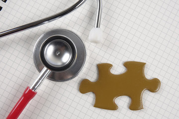 Medical concept with stethoscope,piece of puzzle and coins .