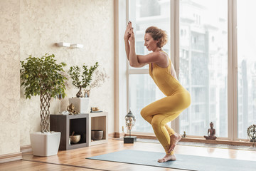 Happy female yogi exercising with enjoyment