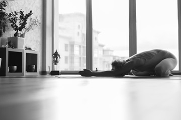 Peaceful female yogi exercising in apartment