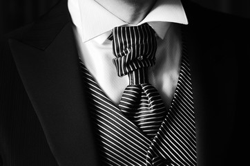 Dettaglio di abito da sposo con cravatta camicia bianca giacca gilet  righe bianche e nere