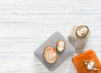 Woman's Jewelry. Vintage jewelry background. Beautiful vintage cameo brooches and jewelry boxes on white background. Flat lay, top view.