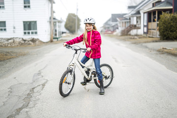 Little girl riding a bike in a city