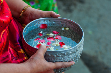 Thai Songkran festival,  elder hand holding bowl with flower