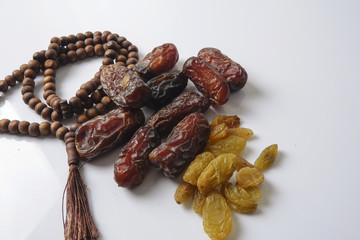 Dates,raisin and rosary isolated on white.