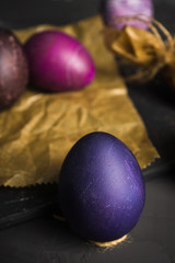 Rustic colored easter eggs on the dark stone background. Shallow depth of field.