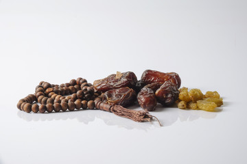 Dates,raisin and rosary isolated on white.