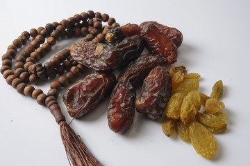 Dates,raisin and rosary isolated on white.