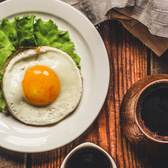  Fried eggs, lettuce, freshly brewed coffee on a wooden surface