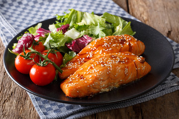 Spicy salmon with sesame seeds and fresh vegetables close-up. horizontal