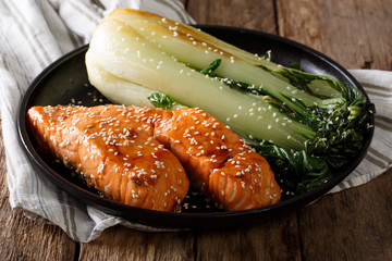 Glazed salmon fillet with sesame seeds and roasted cabbage bok choy close-up. horizontal - obrazy, fototapety, plakaty