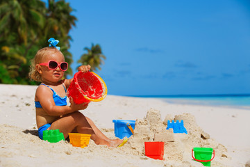 cute little girl play with sand on beach