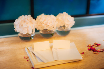 Open empty copy book with dried roses. Blank creamy pages.