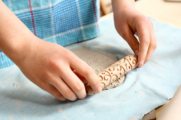 Zdobienie ceramiki.Kobiece dłonie lepią z gliny.