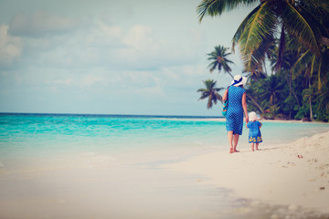 Fototapeta na wymiar mother and little daughter walking on beach