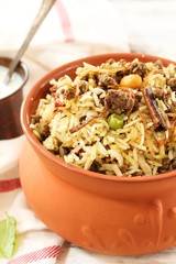 Matka ( pot)   Biryani served with yogurt dip, selective focus