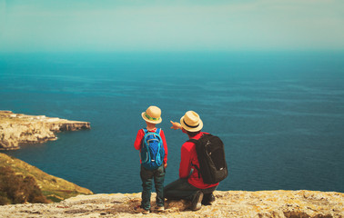 family travel - father and son hiking in mountains at sea