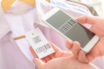 Woman scanning barcode with mobile phone