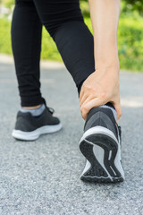 Obraz premium Młoda kobieta sport fitness biegacz dotykając jej nogi i kostki w bolesnym, wypadku sportowym raniącym uczucie bólu stawu lub mięśni
