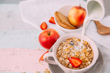 Granola bowl with milk and apples. Healthy breakfast