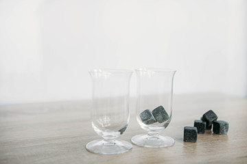 Stones for cooling whiskey and glases tulup on light wooden background