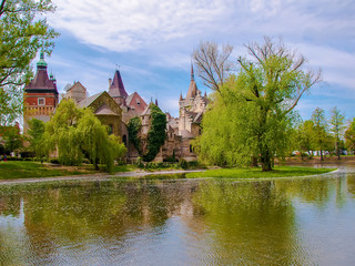 Scenic view of Vajdahunyad Castle reflected in the lake under the blue sky in main City Park, Budapest, Hungary