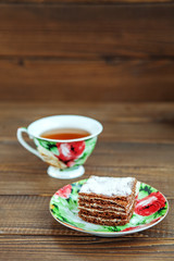 Delicious cake and a cup of hot tea on wooden background. The concept of food and dessert.