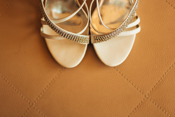 silver Bride shoes on a bed before ceremony. wedding concept