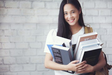 Asian students holding books at university